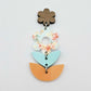 Assembled three-piece acrylic floral dangle hanging from a 14mm walnut flower topper, Floral Bloom UV printed flower with aqua and orange layered leaf pieces