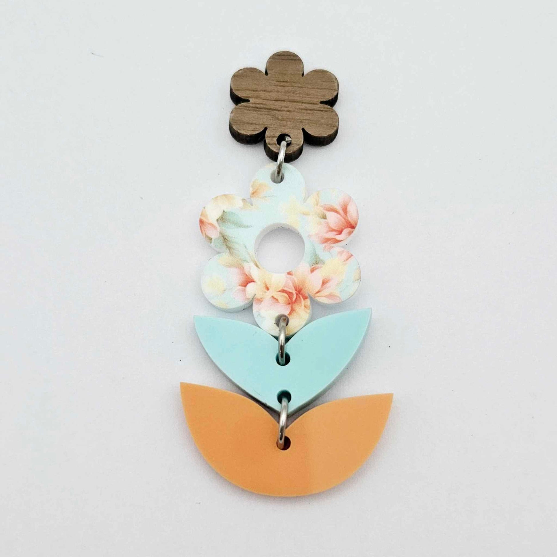Assembled three-piece acrylic floral dangle hanging from a 14mm walnut flower topper, Floral Bloom UV printed flower with aqua and orange layered leaf pieces
