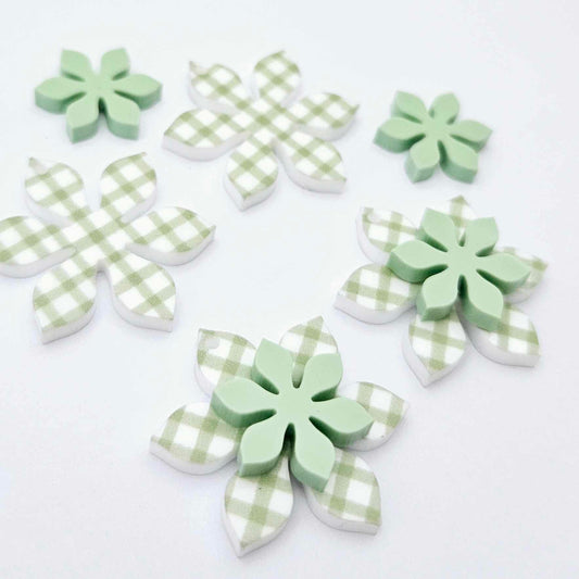 Green gingham UV print and pastel green acrylic two layer flower dangle blanks shown laying flat, with some flowers stacked to show layered effect and others positioned side by side