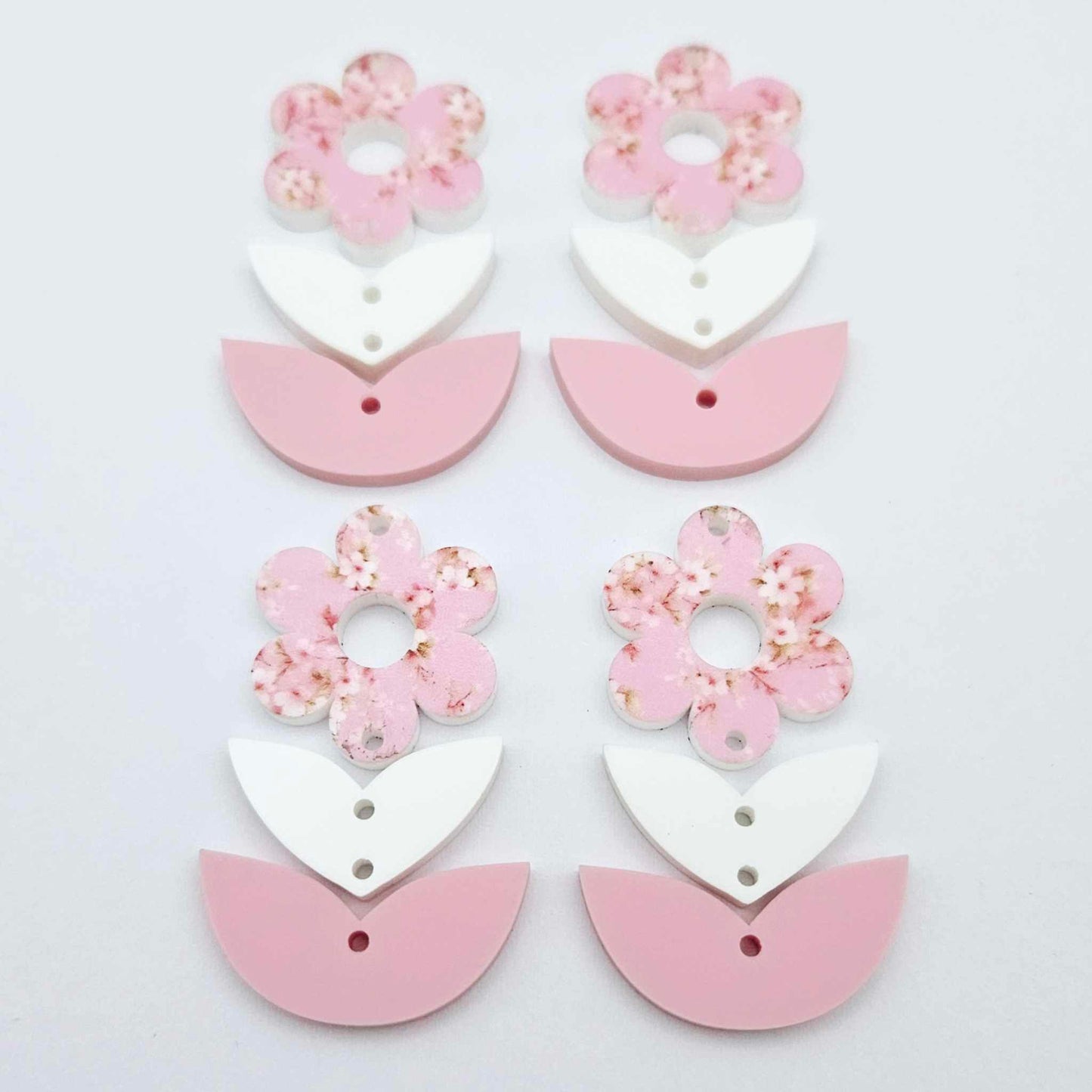 Three-piece acrylic flower dangle blanks shown unassembled laying flat, featuring Cherry Blosoom UV printed flower, white leafy middle and pastel pink leafy bottom