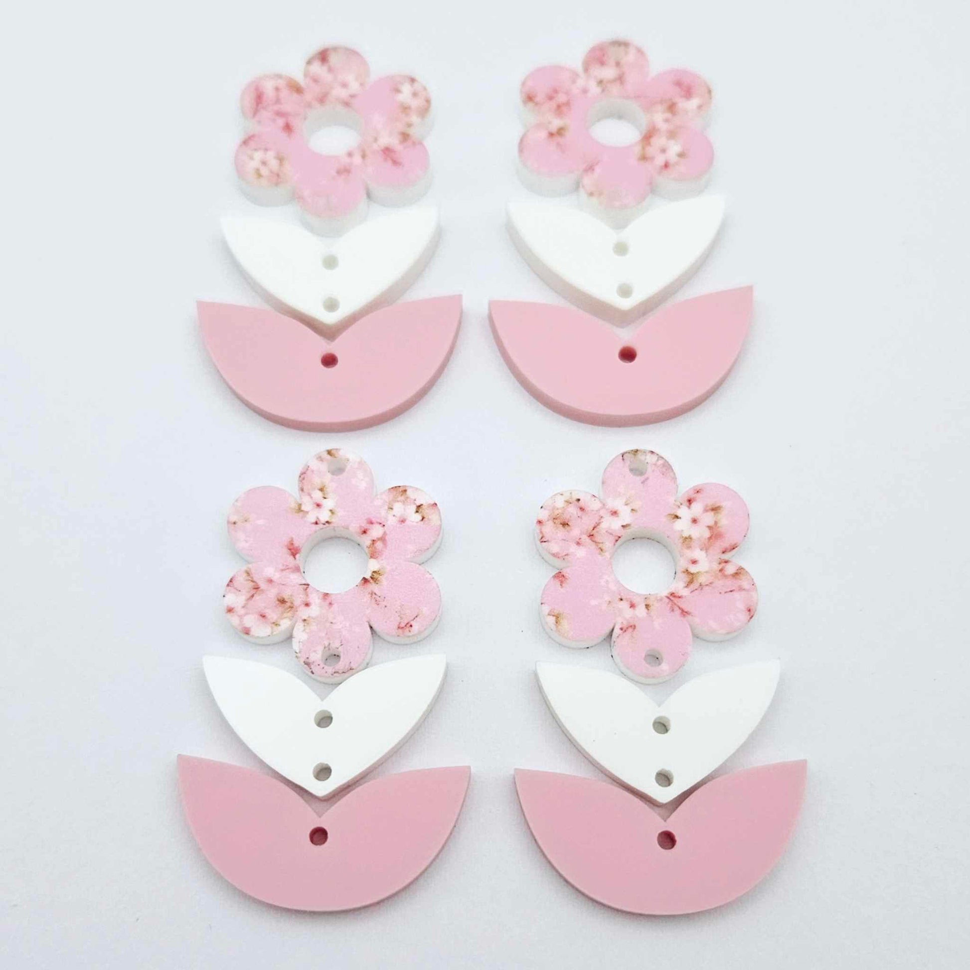 Three-piece acrylic flower dangle blanks shown unassembled laying flat, featuring Cherry Blosoom UV printed flower, white leafy middle and pastel pink leafy bottom