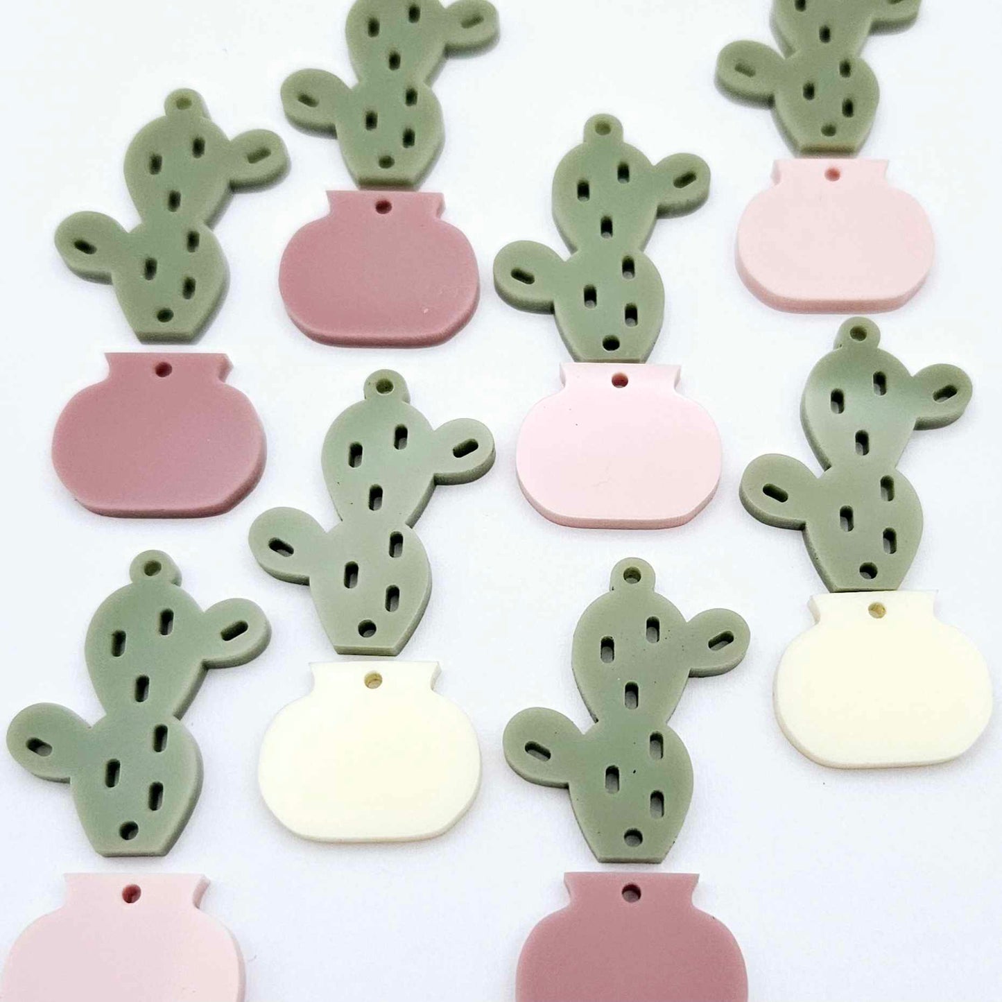 Two-piece acrylic cactus dangle blanks in olive green with mixed coloured pots, shown unassembled with cactus top and pot bottom pieces laid flat