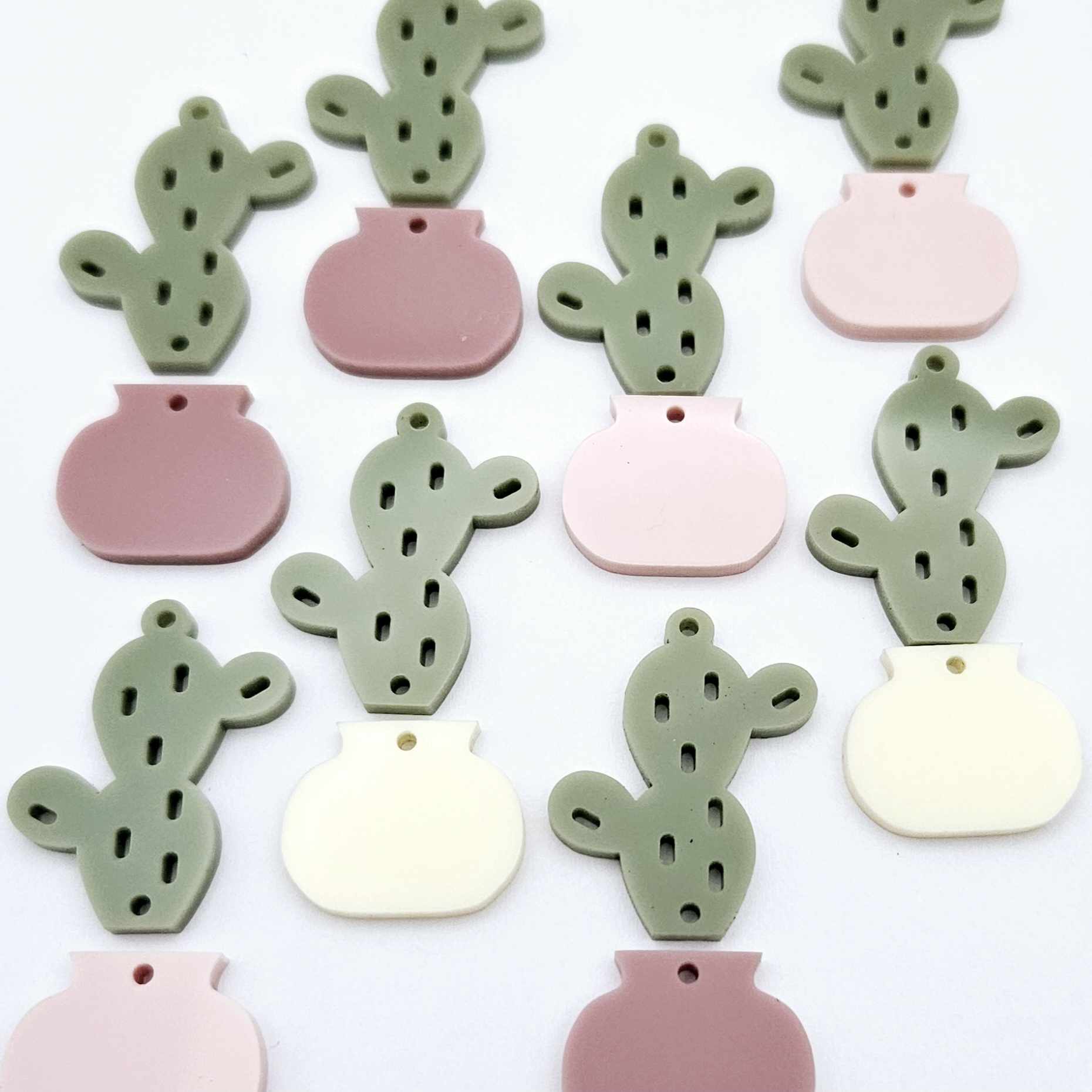 Two-piece acrylic cactus dangle blanks in olive green with mixed coloured pots, shown unassembled with cactus top and pot bottom pieces laid flat