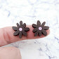 17mm chocolate brown acrylic flower stud blanks with engraved centre detail, one pair paint filled light pink shown on finger for size reference