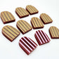 Port wine striped arch stud blanks with engraved stripes, one pair paint filled light pink and peeled, with additional unpainted pieces shown with protective film on