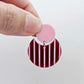 Nested circle acrylic dangle earring with pastel pink topper and port wine striped base, paint filled light pink and fully assembled to show finished look