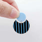 Nested circle acrylic dangle earring with pastel blue topper and chocolate brown striped base, paint filled light blue and fully assembled to show finished look