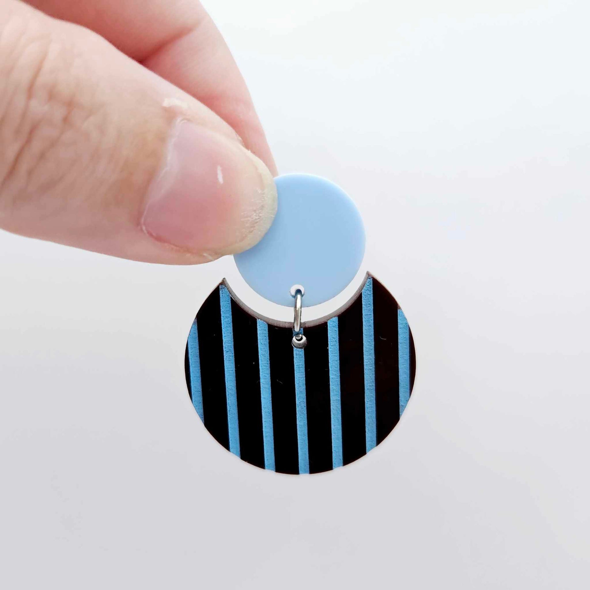 Nested circle acrylic dangle earring with pastel blue topper and chocolate brown striped base, paint filled light blue and fully assembled to show finished look