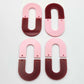 Layered U dangle blanks in pastel pink and port wine (burgundy) acrylic, two pairs shown unassembled laying flat with matching U-shaped pieces