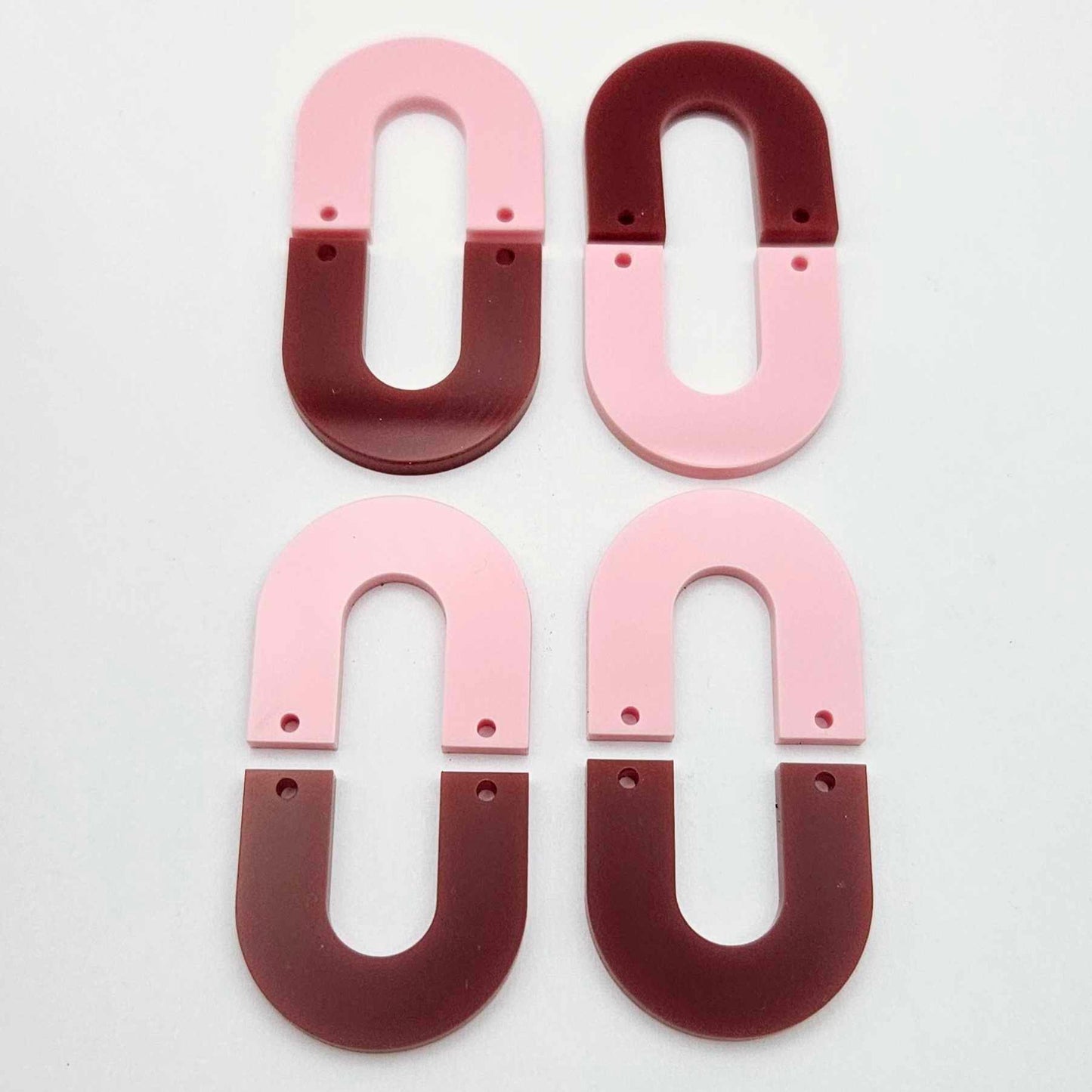 Layered U dangle blanks in pastel pink and port wine (burgundy) acrylic, two pairs shown unassembled laying flat with matching U-shaped pieces
