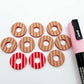 22mm red striped acrylic hoop stud blanks showing paint filled example and unpainted pieces with protective film, pictured with a light pink Posca paint pen