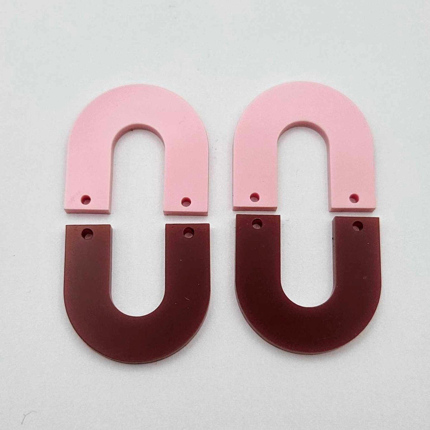 Layered U dangle blanks in pastel pink and port wine (burgundy) acrylic, one pair shown unassembled laying flat with matching U-shaped pieces