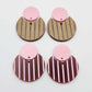 Nested circle dangle blanks showing one pair paint filled light pink and peeled, with another pair unpainted and with protective film on