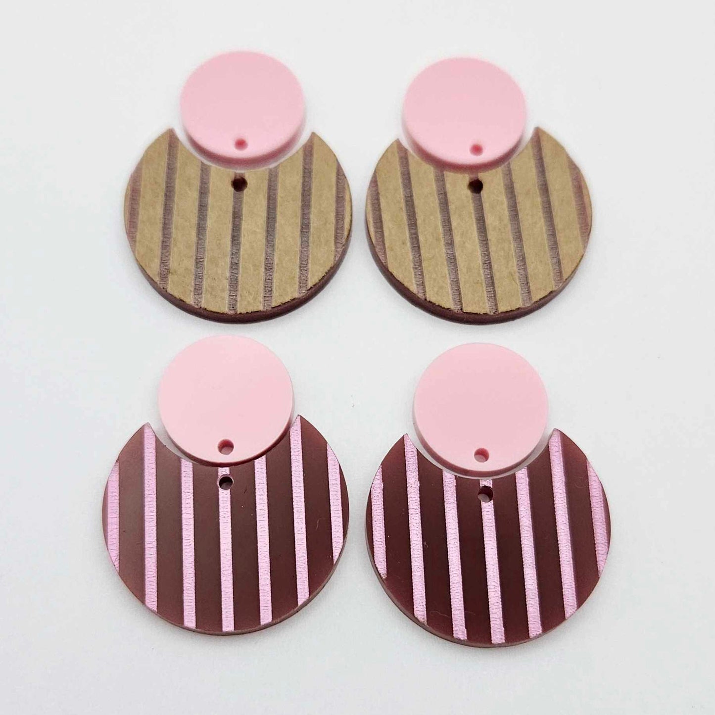 Nested circle dangle blanks showing one pair paint filled light pink and peeled, with another pair unpainted and with protective film on
