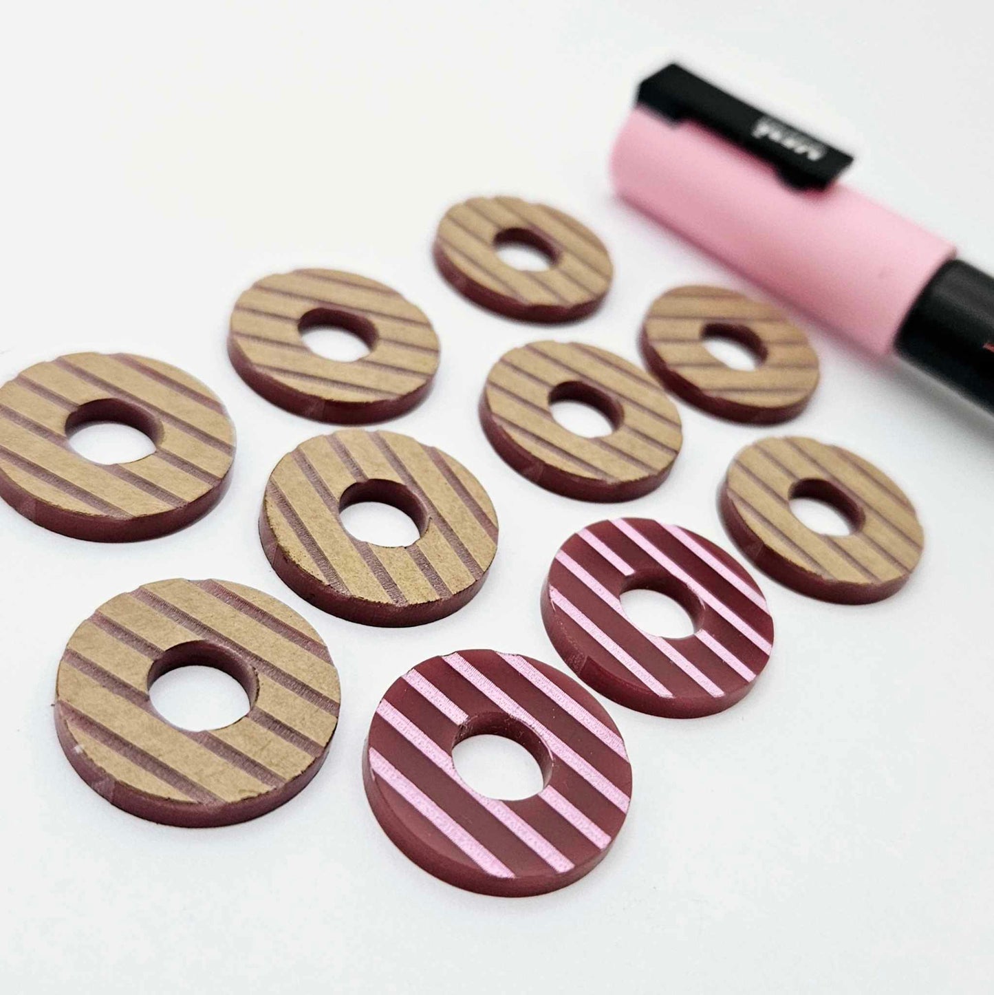 22mm port wine (burgundy) striped acrylic hoop stud blanks showing paint filled example and unpainted pieces with protective film, pictured with a light pink Posca paint pen