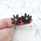 17mm chocolate brown acrylic flower stud blanks with engraved centre detail, one pair paint filled light blue shown on finger for size reference
