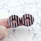 22mm chocolate brown striped hoop acrylic stud blanks paint filled with light pink, shown on a finger for size reference and finished look