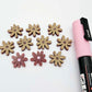 Port wine (Maroon) acrylic flower stud blanks showing paint filled light pink example and unpainted pieces with protective film, pictured with a light pink Posca paint pen