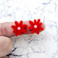 17mm red acrylic flower stud blanks with engraved centre detail, one pair paint filled light pink shown on finger for size reference