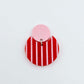 Nested circle acrylic dangle earring with pastel pink topper and red striped base, paint filled light pink and fully assembled to show finished look