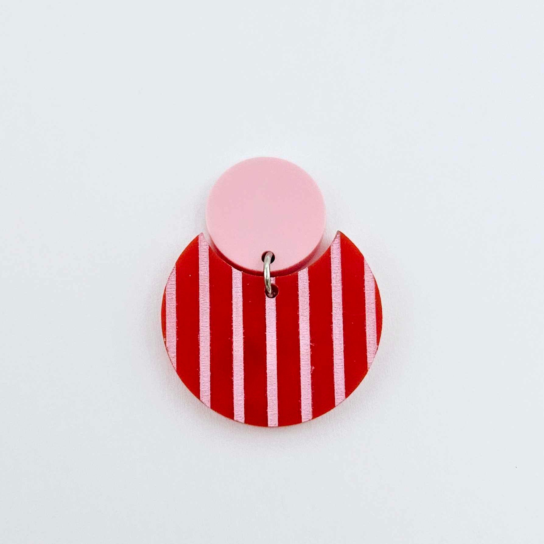 Nested circle acrylic dangle earring with pastel pink topper and red striped base, paint filled light pink and fully assembled to show finished look