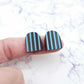 16mm chocolate brown striped arch acrylic stud blanks paint filled with light blue, shown on a finger for size reference and finished look