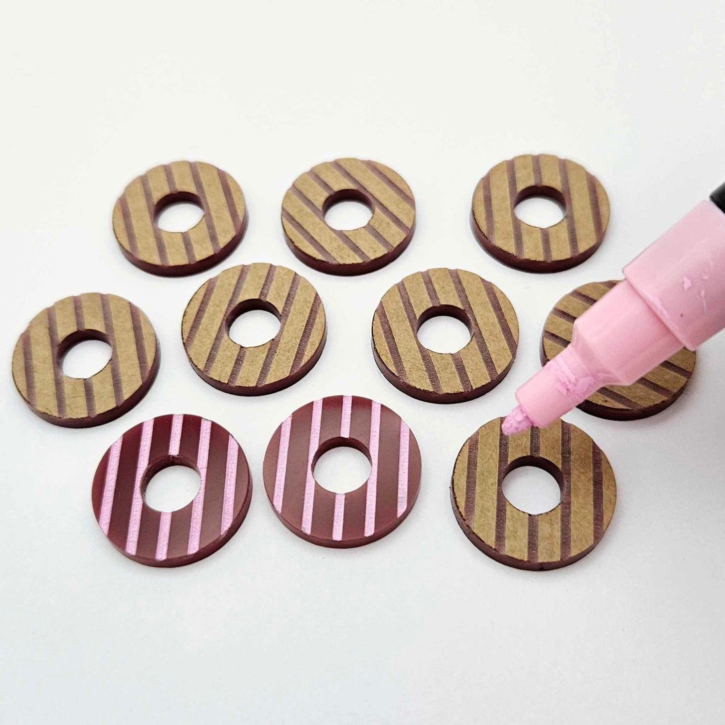 22mm port wine (burgundy) striped acrylic hoop stud blanks showing paint filled example and unpainted pieces with protective film, pictured with a light pink Posca paint pen