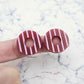 22mm port wine (burgundy) striped hoop acrylic stud blanks paint filled with light pink, shown on a finger for size reference and finished look
