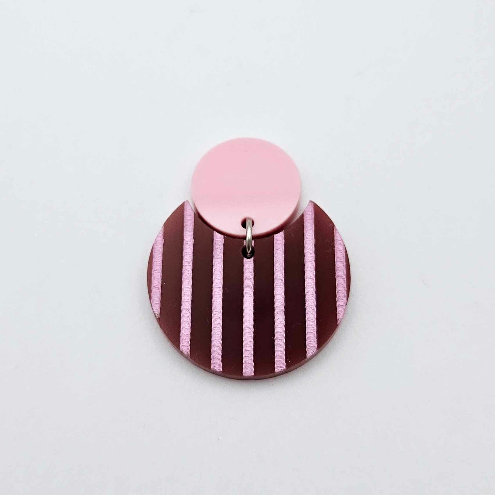 Nested circle acrylic dangle earring with pastel pink topper and port wine striped base, paint filled light pink and fully assembled to show finished look