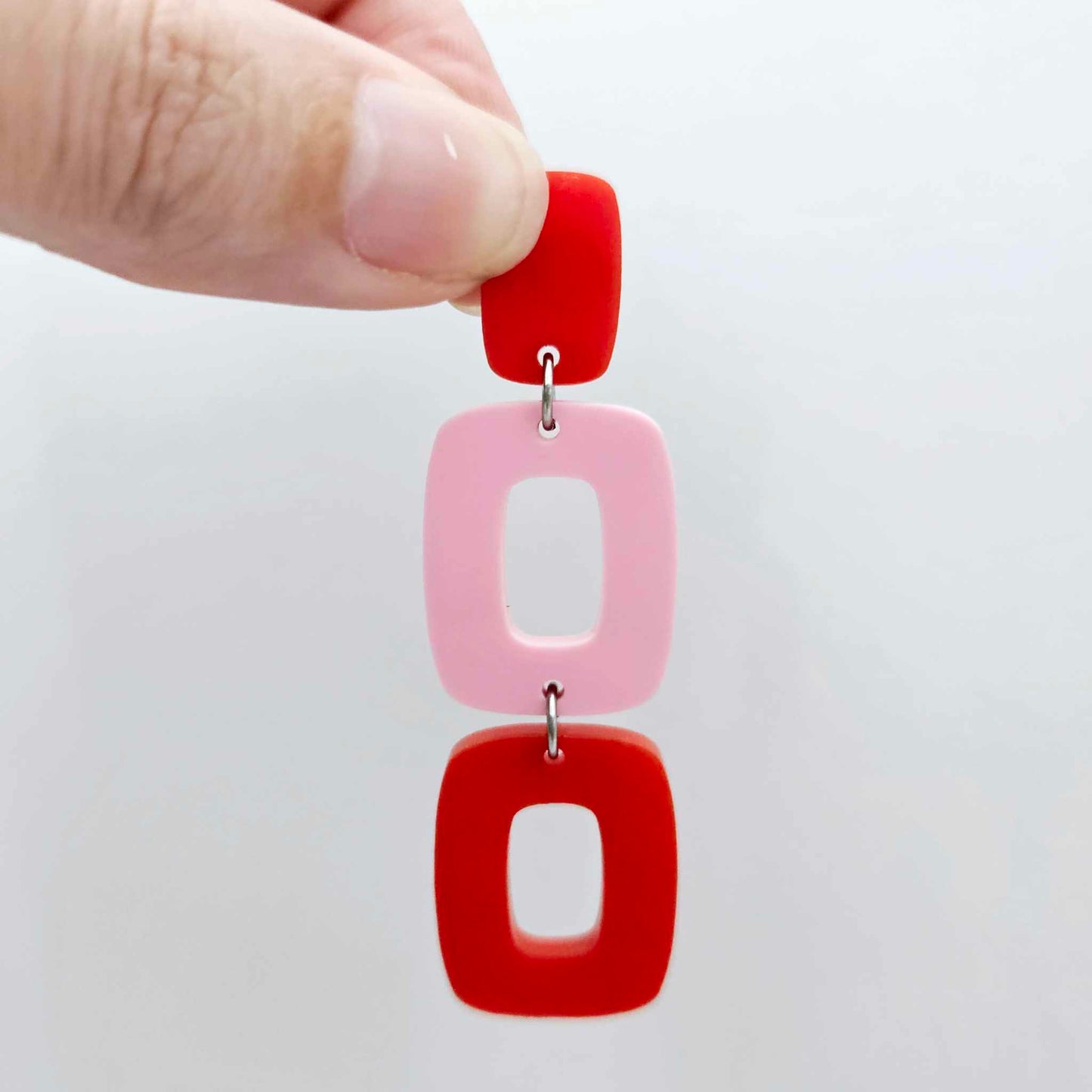 Assembled layered rectangle dangle earring in red and pastel pink acrylic, three-piece geometric statement design