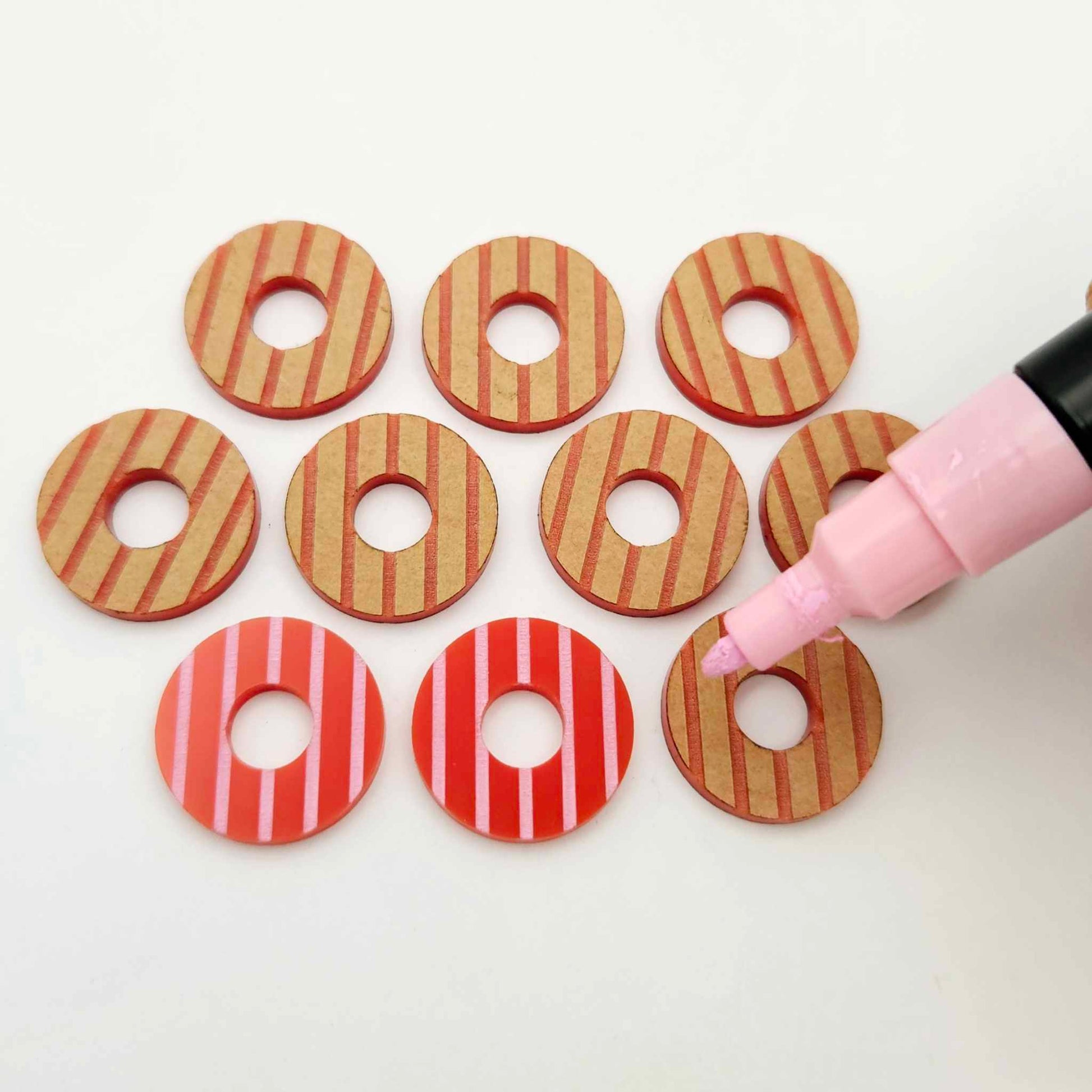 22mm red striped acrylic hoop stud blanks showing paint filled example and unpainted pieces with protective film, pictured with a light pink Posca paint pen