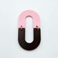 Layered U shape dangle earring in pastel pink and chocolate brown acrylic, assembled into an open oval design hanging as a statement stud dangle
