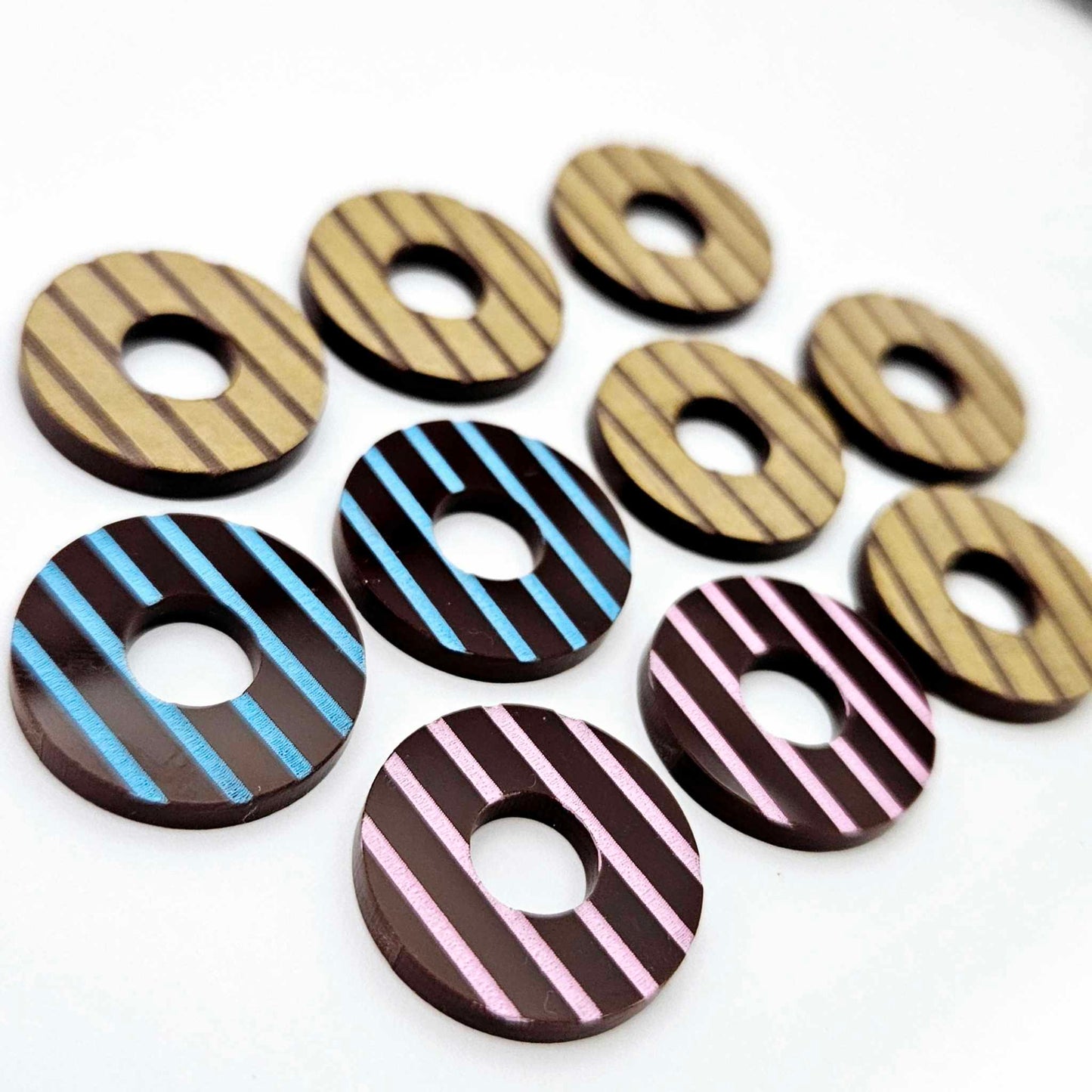 22mm chocolate brown acrylic striped hoop stud blanks with engraved stripes, one pair paint filled light pink and one light blue and peeled, with additional unpainted pieces shown with protective film on