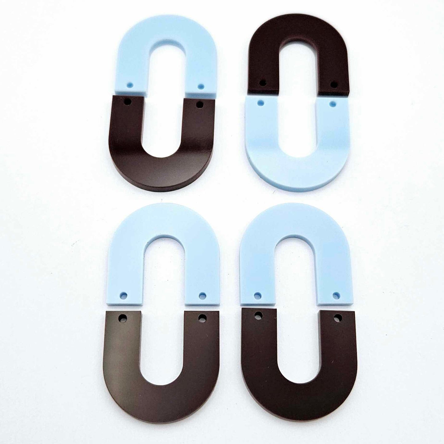 Layered U dangle blanks in pastel blue and chocolate brown acrylic, two pairs shown unassembled laying flat with matching U-shaped pieces