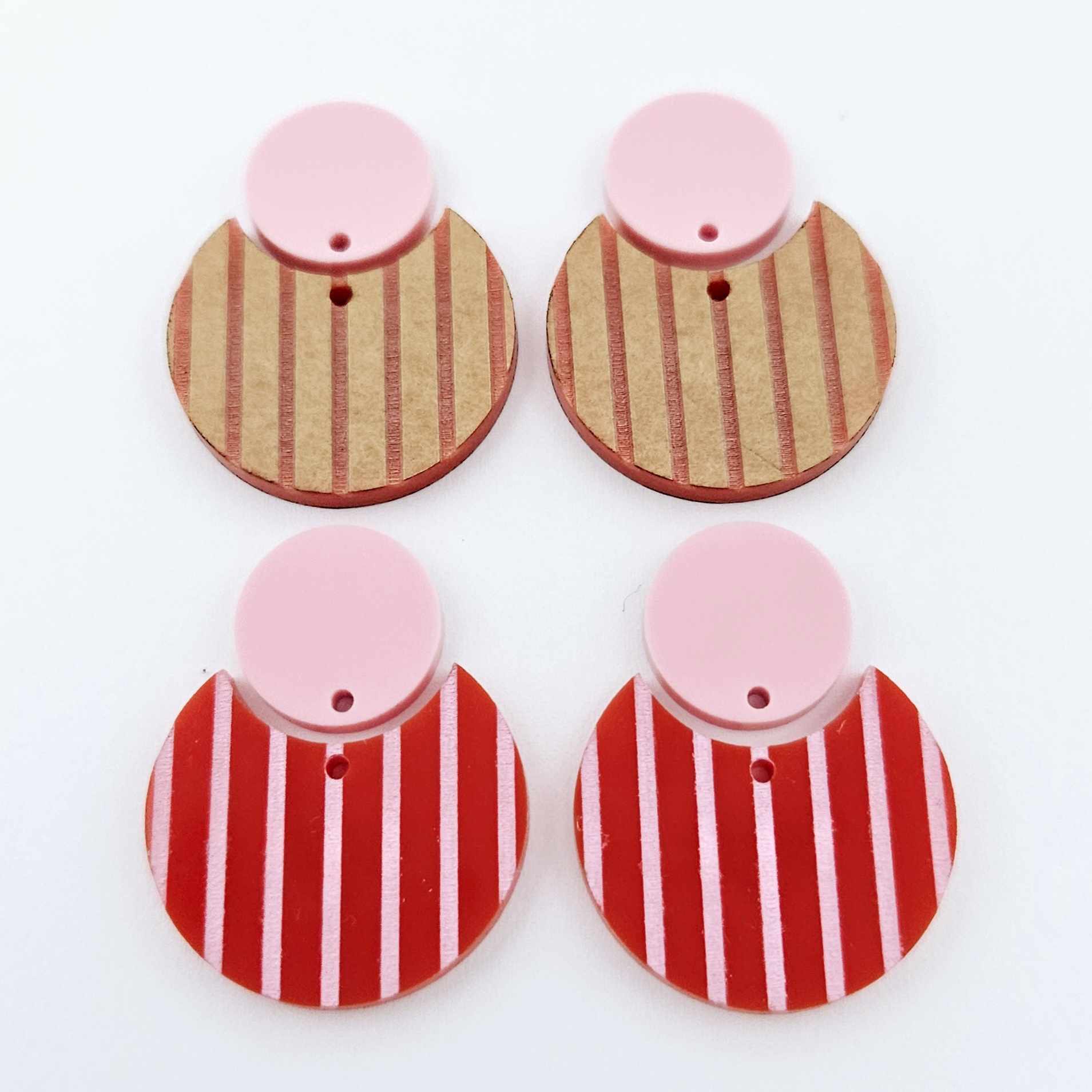 Nested circle dangle blanks showing one pair paint filled light pink and peeled, with another pair unpainted and with protective film on