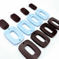 Two pairs of layered rectangle dangle blanks in chocolate brown and pastel blue acrylic, unassembled pieces laid flat showing three-piece design