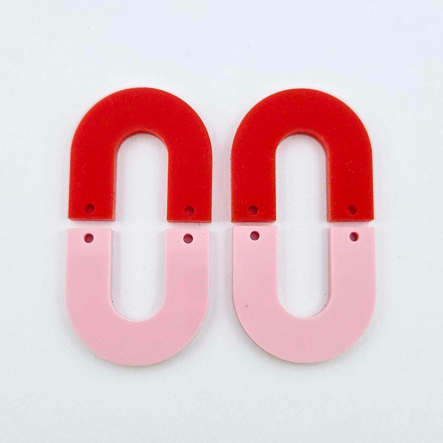 Layered U dangle blanks in pastel pink and red acrylic, one pair shown unassembled laying flat with matching U-shaped pieces