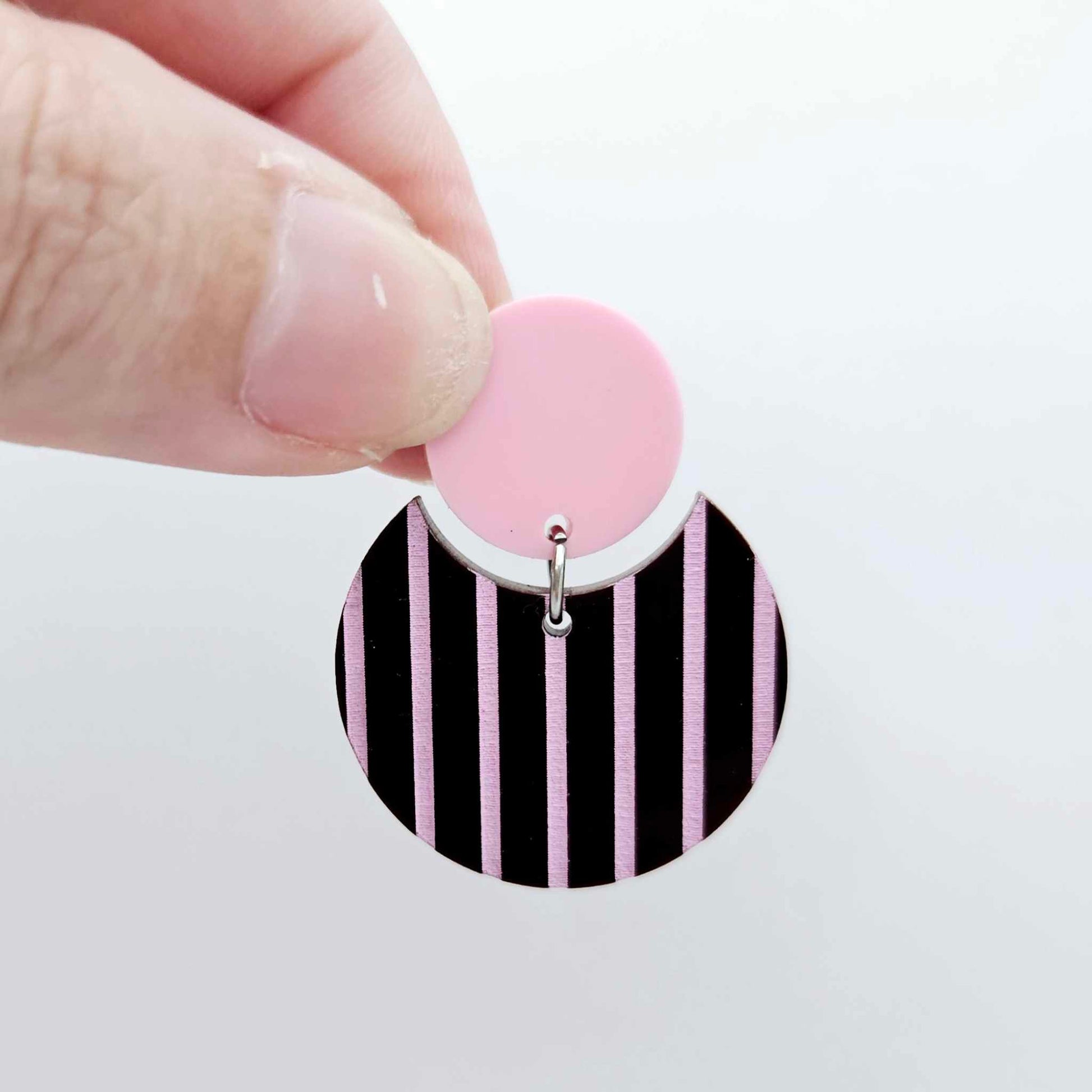 Nested circle acrylic dangle earring with pastel pink topper and chocolate brown striped base, paint filled light pink and fully assembled to show finished look