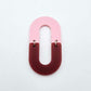 Layered U shape dangle earring in pastel pink and port wine (burgundy) acrylic, assembled into an open oval design hanging as a statement stud dangle