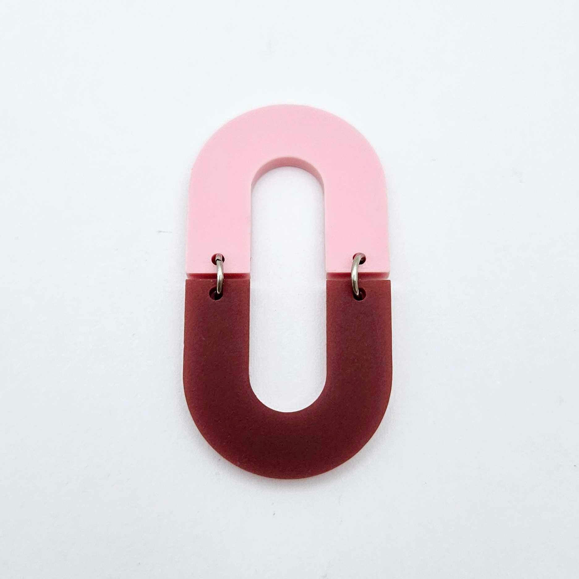 Layered U shape dangle earring in pastel pink and port wine (burgundy) acrylic, assembled into an open oval design hanging as a statement stud dangle
