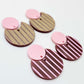 Nested circle dangle blanks showing one pair paint filled light pink and peeled, with another pair unpainted and with protective film on