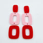 Layered rectangle dangle blanks in red and pastel pink, one pair shown unassembled laying flat with rectangle topper and two hoop pieces