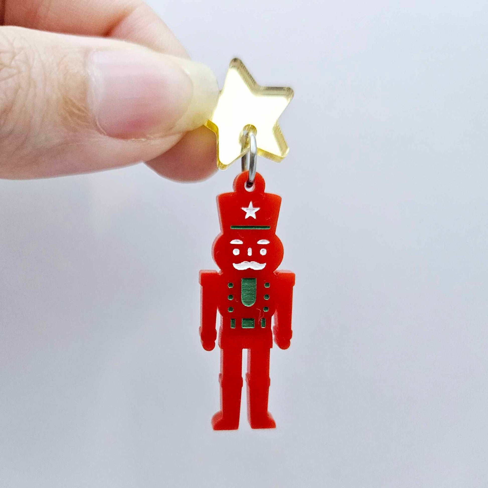 Assembled 40mm nutcracker Christmas dangle earrings in red acrylic with engraved detail paint filled with green and white