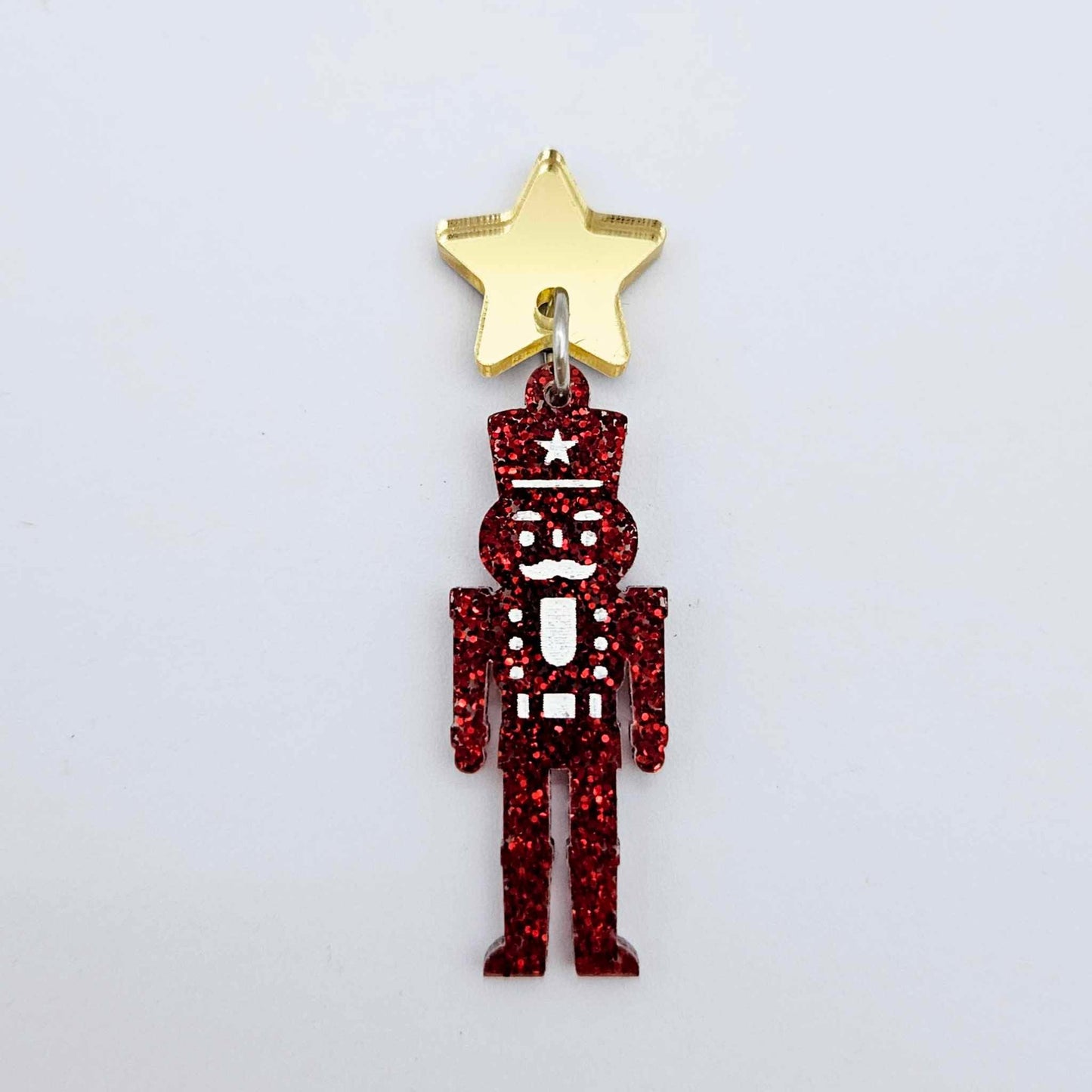 Assembled 40mm nutcracker Christmas dangle earrings in red glitter acrylic with engraved detail paint filled white