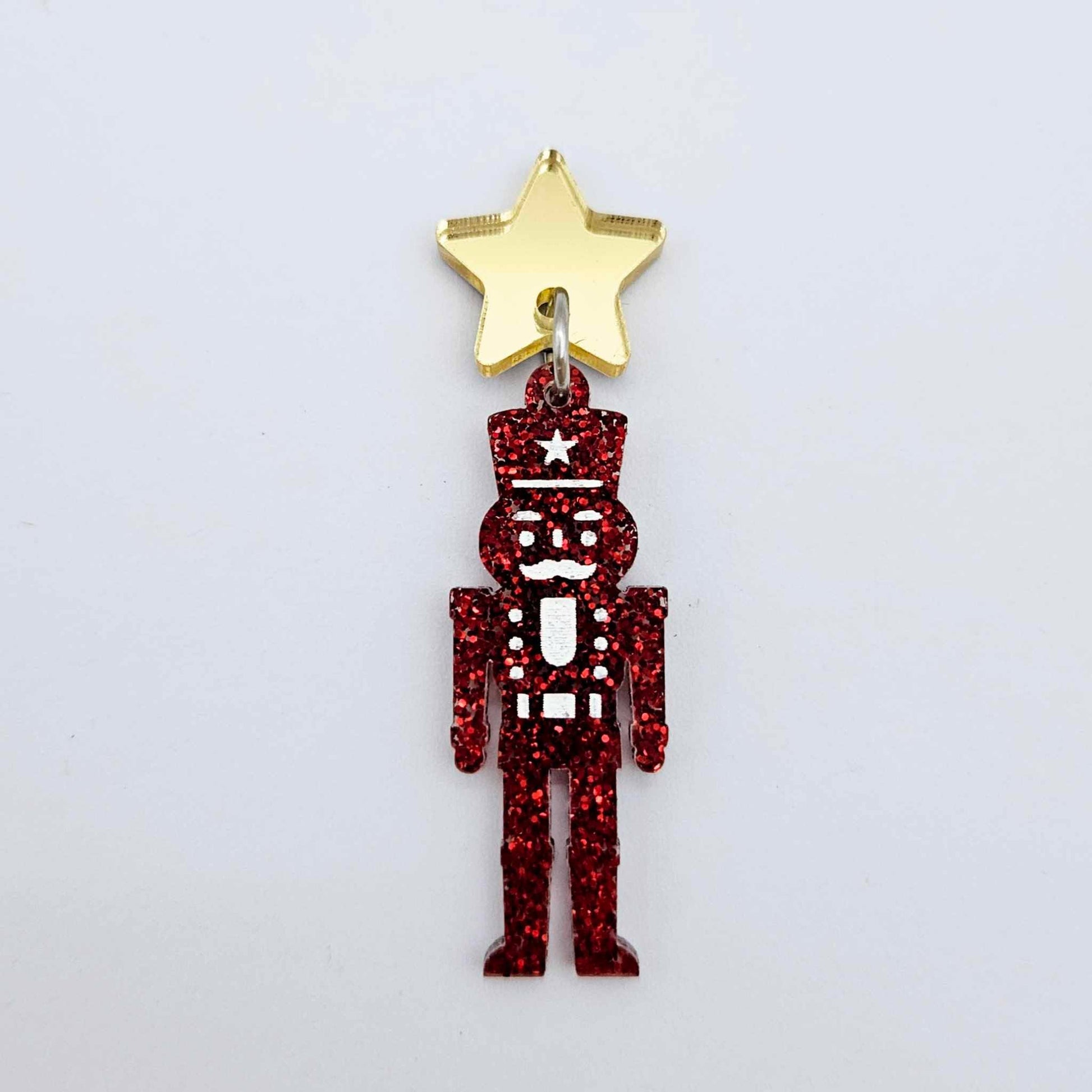 Assembled 40mm nutcracker Christmas dangle earrings in red glitter acrylic with engraved detail paint filled white