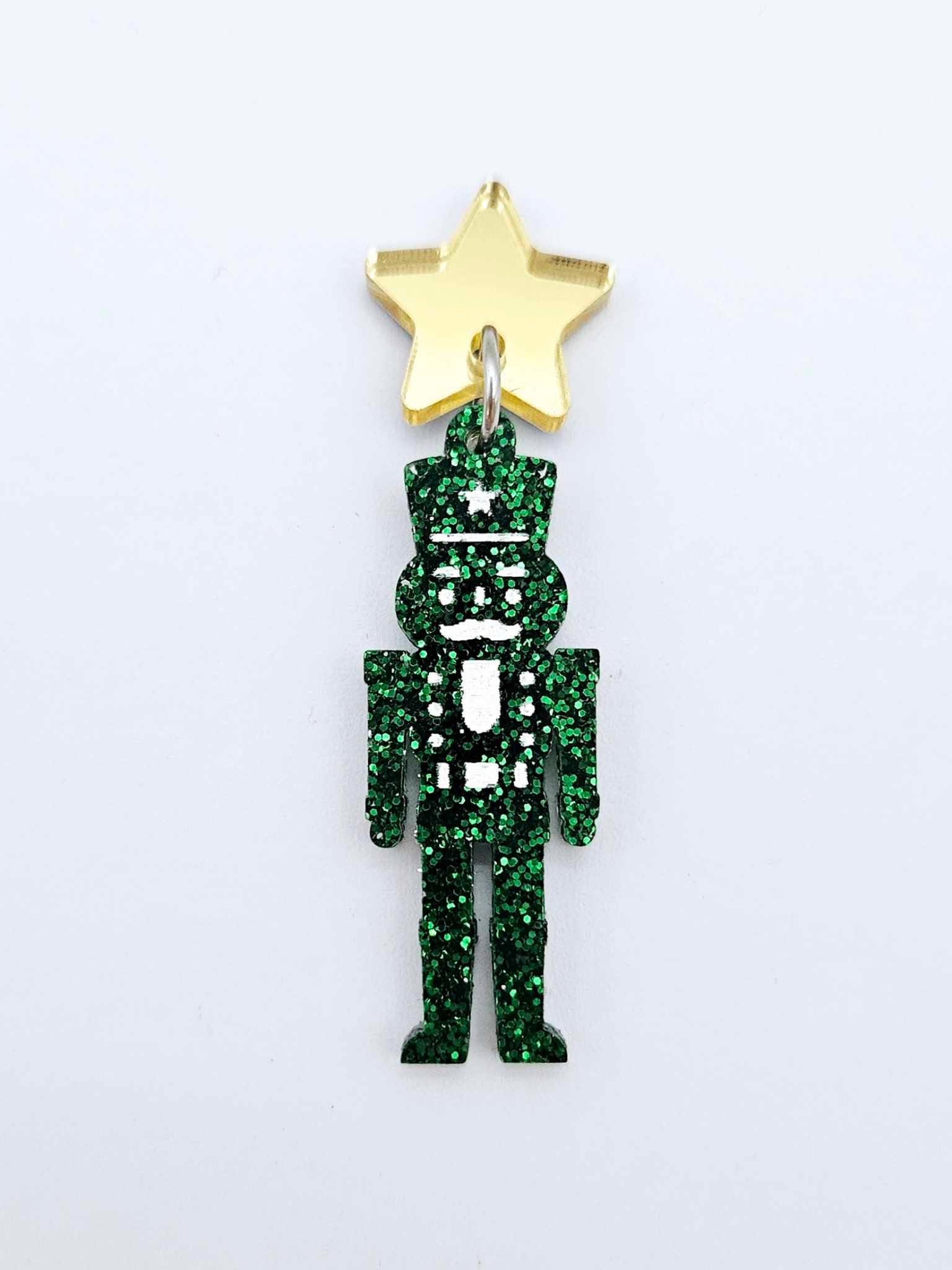 Assembled 40mm nutcracker Christmas dangle earrings in green glitter acrylic with engraved detail paint filled white