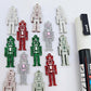 40mm nutcracker Christmas dangle blanks with engraved paint-fill details shown in green, red and silver glitter acrylic