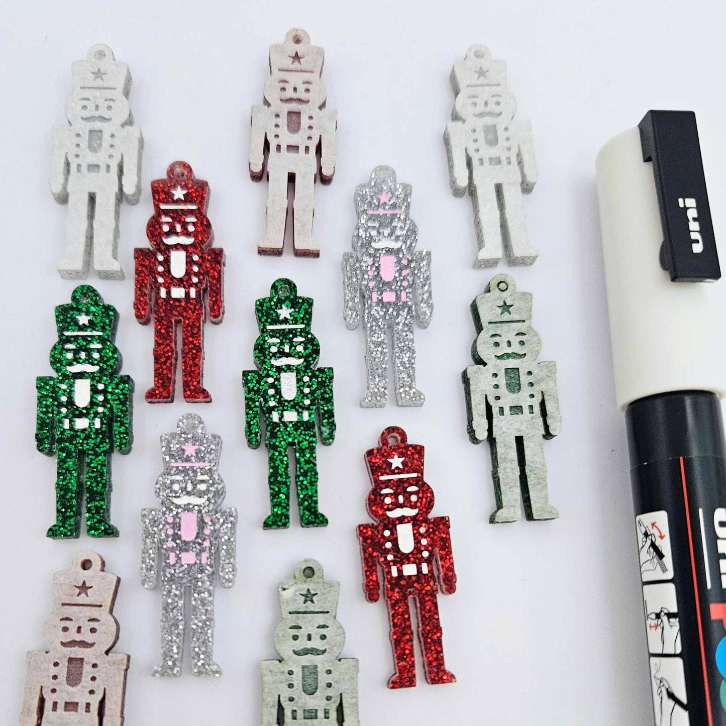 40mm nutcracker Christmas dangle blanks with engraved paint-fill details shown in green, red and silver glitter acrylic