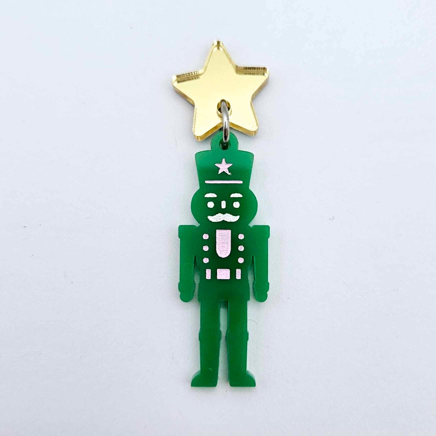 Assembled 40mm nutcracker Christmas dangle earrings in green acrylic with engraved detail paint filled with pink and white
