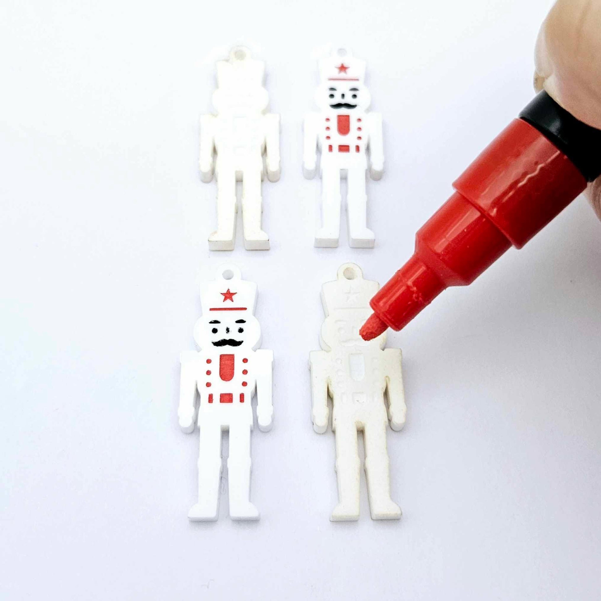 40mm nutcracker Christmas dangle blanks with engraved paint-fill details shown in  white acrylic with red posca paint pens